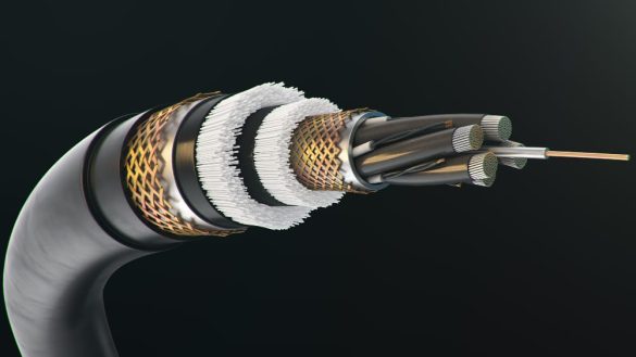 Gros plan détaillé sur l'extrémité dénudée d'un câble blindé industriel multicœur, montrant les différentes couches de protection métalliques, l'isolation et les conducteurs internes.